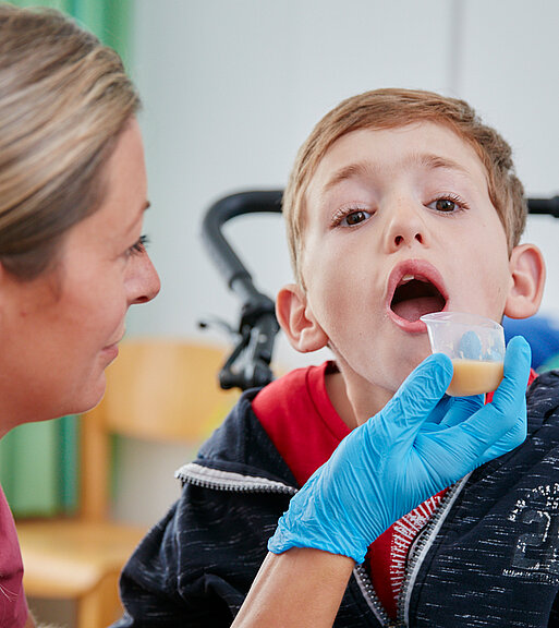 Picture: By administering some juice, the therapist tests a boy's swallowing behaviour.