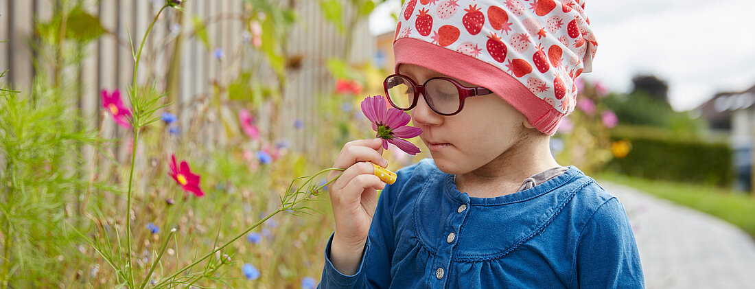 Picture: A child smells a flower in the garden of the children's clinic