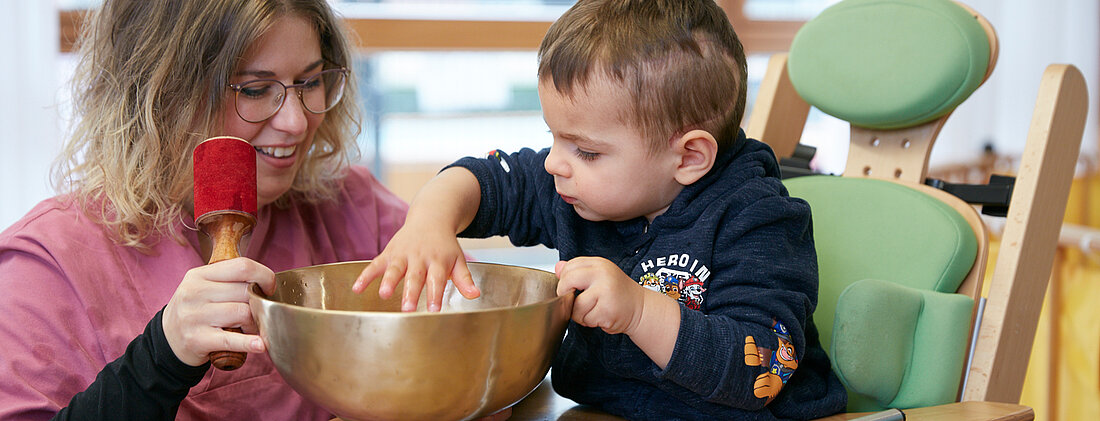 Picture: The therapist works with a singing bowl for a toddler to improve body awareness.