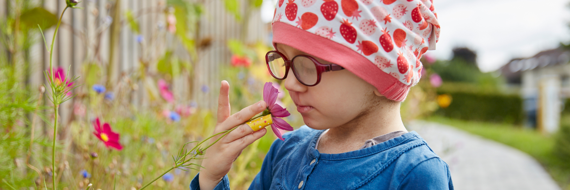 Picture: A girl smells a flower in the garden of the children's hospital Schömberg